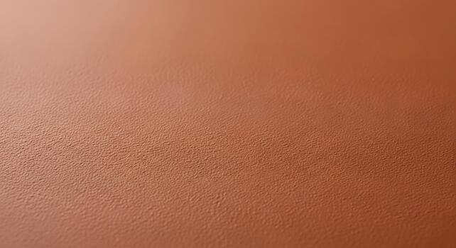 Close-up of a textured brown surface, showcasing a subtle, organic grain pattern with a warm, earthy hue and soft lighting photo
