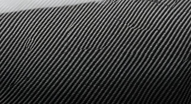 Detailed close-up of a dark woven synthetic fabric, showcasing its intricate diagonal pattern and robust texture, ideal for high-tech industrial design and modern material applications photo