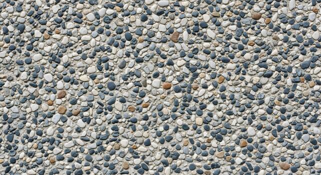 Close-up of a resilient exposed aggregate surface, highlighting the intricate natural texture created by numerous small, multi-toned pebbles, perfect for modern design elements photo
