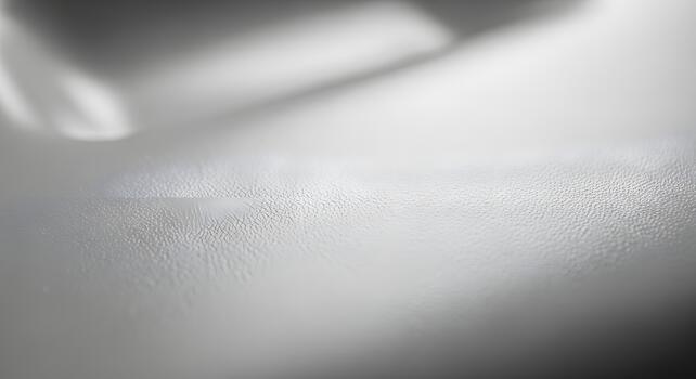 Abstract texture of a smooth, reflective, and slightly cracked surface with soft shadows photo