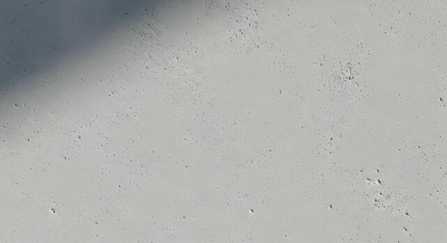 Minimalist textured grey concrete surface with subtle natural imperfections and gentle shadows creating a versatile abstract background for modern design and architectural concepts photo