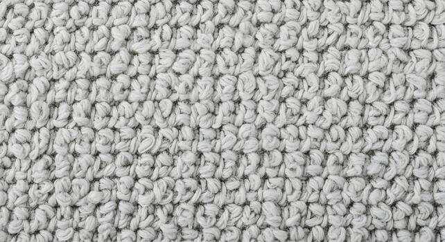 Detailed macro shot of a plush, neutral grey fabric revealing its unique textured surface and intricate woven pattern, providing a versatile background for various design projects photo