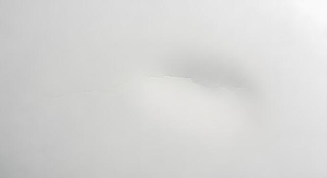 White surface with faint cracks and subtle undulations, presenting an abstract and minimalist background texture perfect for overlay or design applications photo