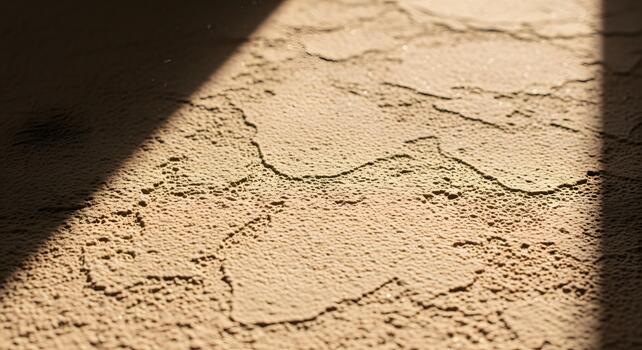 Close-up texture of desert sand with sunlight casting a shadow, showcasing intricate patterns and granular details photo