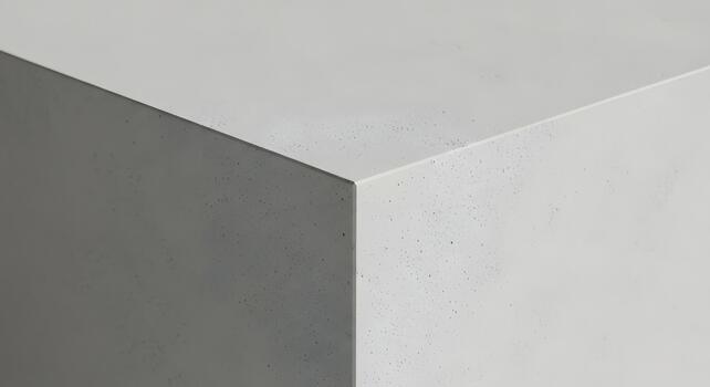 Abstract close-up of a light gray concrete block, showcasing the rough texture and sharp geometric edges, perfect for a minimalist background or industrial design concept photo