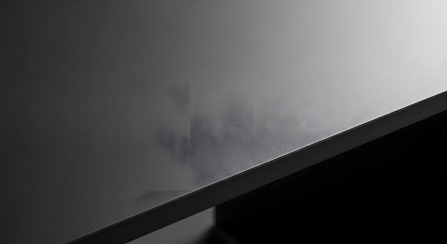 Close-up of a sleek, dark surface showcasing a subtle, intricate texture and delicate light reflections, creating an abstract and contemporary background for various design needs photo