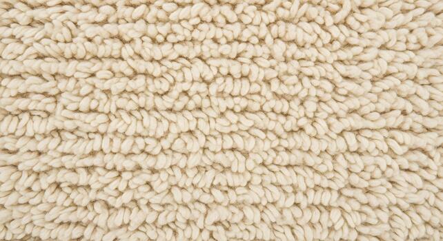 Close-up macro view of a soft, plush, cream-colored fabric texture with dense, looped fibers creating a warm and inviting surface photo