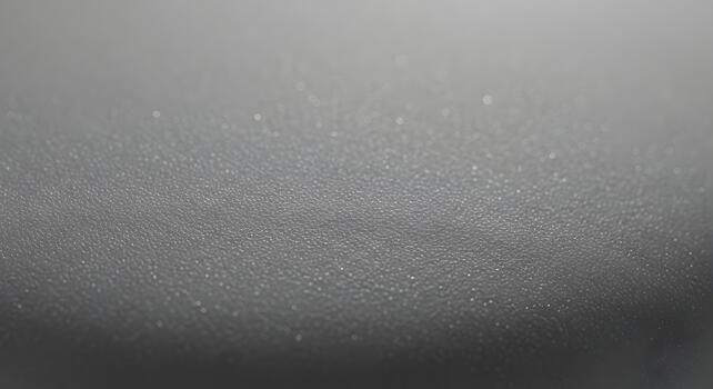 Detailed close-up of a subtle dark grey texture with a fine granular pattern, emphasizing its abstract nature and suitability as a versatile background photo