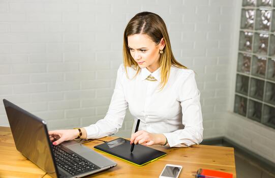 Woman designer using graphics tablet while working with computer. photo