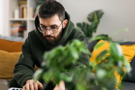 Close-up Man recording electronic music track with portable midi keyboard on laptop computer in home studio. Producing and mixing music beat making and arranging audio content photo