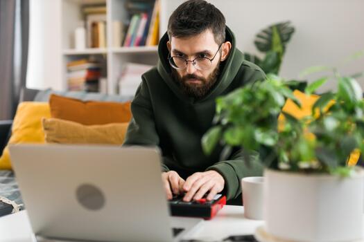 Portrait Male music producer or arranger using laptop and midi keyboard and other audio equipment to create music at home studio. Beat making and arranging audio content and composing song concept photo