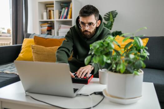 Close-up Man music producer or arranger using laptop and midi keyboard and other audio equipment to create music at home studio. Beat making and arranging audio content and composing song concept photo