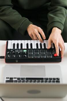 Top view of a music producer or arranger using laptop and midi keyboard and other audio equipment to create music at home studio. Beat making and arranging audio content and composing song photo