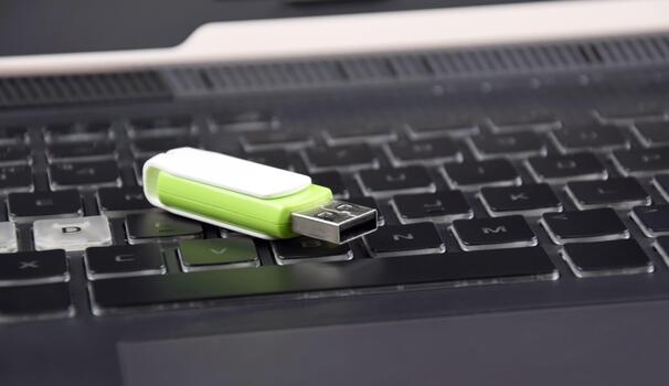 One USB memory stick or flash drive on the keyboard of an open laptop. photo