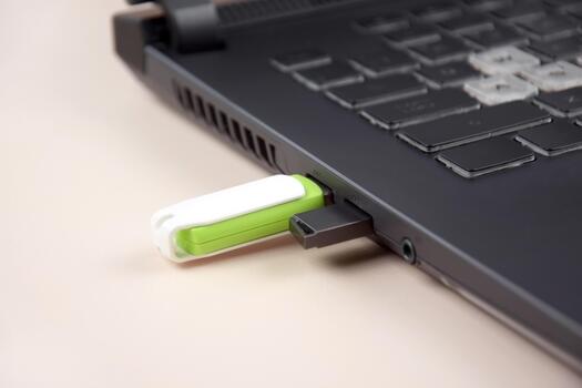 USB memory stick or flash drive on the keyboard of an open laptop. photo