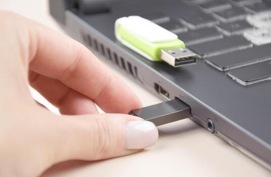 Two USB memory stick or flash drive on the keyboard of an open laptop photo