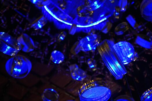 Abstract Low Angle View of Floating Blue Illuminated Lids in Darkness photo