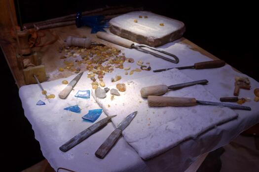 artesanos monitor herramientas y materiales para Roca tallado en un taller ajuste durante noche horas foto