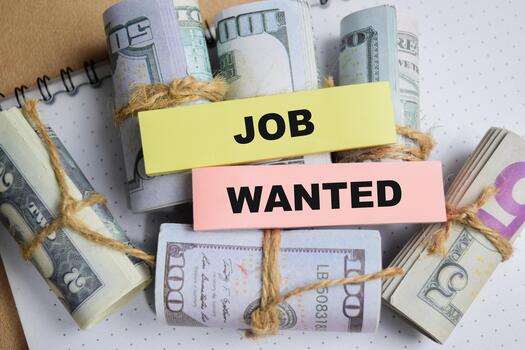 Concept of job wanted write on sticky notes with dollar currency isolated on Wooden Table. photo