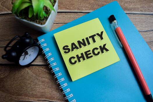 Concept of sanity check write on sticky notes isolated on Wooden Table. photo