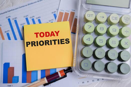 Concept of today priorities write on sticky notes with financial graphs isolated on Wooden Table. photo