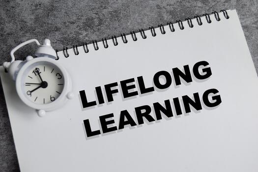 Concept of lifelong learning write on book isolated on Wooden Table. photo