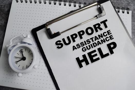 Concept of support help write on clipboard isolated on Wooden Table. photo