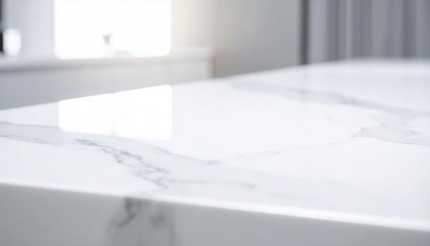 Elegant white marble countertop with subtle veining reflects natural light in a modern kitchen creating a clean and luxurious aesthetic space. photo
