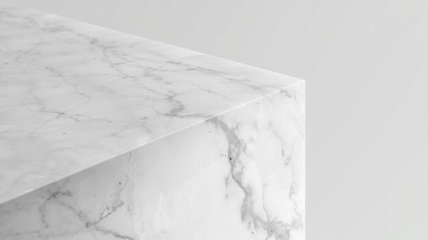 Close up shows a marble block with white veining on a light gray background giving it a modern minimalist aesthetic appeal for displays. photo