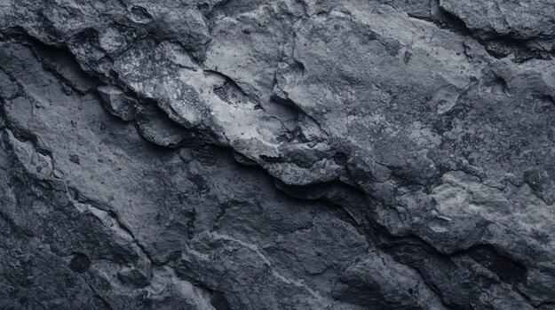 Close up of a dark grey rock surface with deep cracks and textures, creating a rough and natural abstract background, perfect for design. photo
