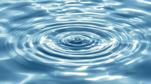 Close up of concentric ripples emanating outward from a single drop of liquid water creating a smooth and calming blue surface texture. photo