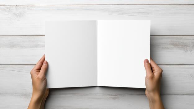 Hands holding open blank book on wooden table photo