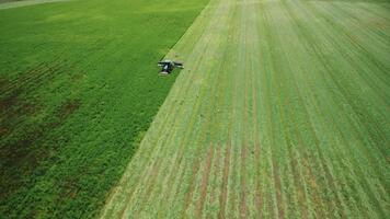 Tractor in field works with high-tech modern mower. Mowing grass with tractor with autopilot. Agricultural process. Cattle forage preparation in dairy farming. Aerial view. Preparation of haylage, hay video