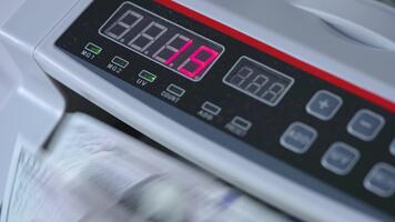 elektronisk tavlan av kontanter räkning maskin med tal på. dollar räkningar roterande i de enhet. stänga upp. video