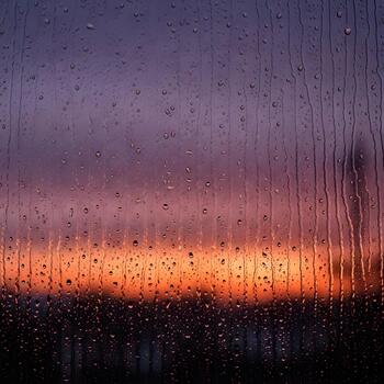 Raindrops on a Window at Sunset Abstract View of a Colorful Sky Through Rain Streaks Creating a Serene and Contemplative Atmosphere with Natural Light photo