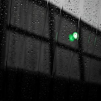 Raindrops on Glass with Abstract Background Featuring Green Lights Reflecting a Melancholy and Introspective Mood Setting a Somber Tone for Reflection photo