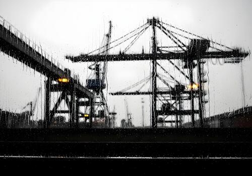 Rainy Day at the Industrial Port with Cranes and Loading Equipment Seen Through a Window with Water Droplets Creating a Unique Visual Effect photo