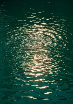 Abstract Water Surface with Light Reflections Creating Circular Patterns and an Emerald Green Hue Evoking Calmness and Serenity for Backgrounds and Textures photo