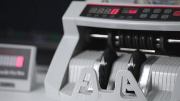 kontanter räkning maskin omkopplas på och de rullar Börja till rotera. en bunt av hundra dollar anteckningar är placerad in i maskin till vara räknas. stänga upp. video