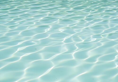 Crystal Clear Water Surface with Sunlight Reflections Rippling and Forming Abstract Patterns Creating a Calming and Serene Environment Suitable for Backgrounds and Designs photo