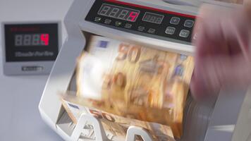 Electronic cash counting machine counts fifty euro banknotes. Figures changing quickly on the counter display at backdrop in blur. Close up. video