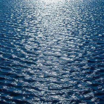 Sparkling Ocean Water Surface with Ripples and Sun Glare Reflecting Beautifully creating abstract patterns in the blue and teal water with a sense of depth and tranquility photo