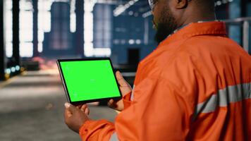 krom nyckel med ingenjör hantering tillverkning genom hopsättning och tillverkning uppgifter använder sig av läsplatta och modern maskineri, demonstrera stark arbetskraft. industriell drift. kamera b. video