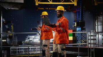 offshore plattform arbetstagare utvärdera risk bedömning rapporter använder sig av bärbar dator, säkerställa effektiv förvaltning av olja och naturlig gas extraktion. fossil bränslen produktion industri. kamera a. video