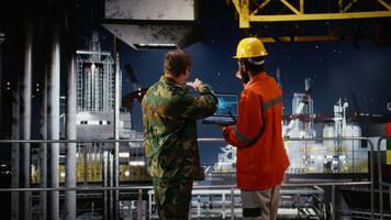 al largo ingegnere e navale ufficiale utilizzando ai tecnologia su il computer portatile per ispezionare perforazione operazioni, Lavorando con il costiero comando inviare per garantire sicuro olio estrazione attività. telecamera un. video