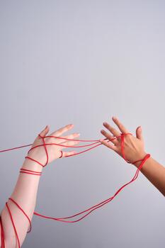 Connected hands creating red string relationship photo