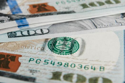 Close-up of stacked hundred dollar bills, showcasing intricate details of currency design, texture, and security features, representing wealth and financial transactions photo