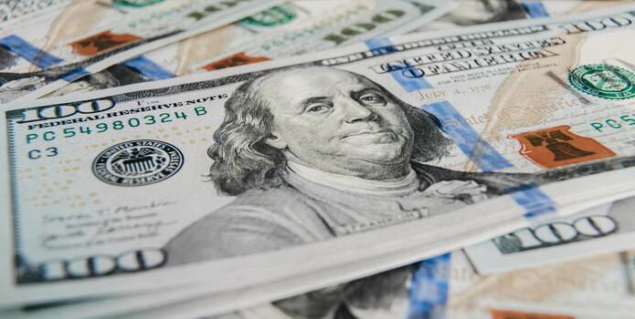 Close-up view of multiple hundred-dollar bills stacked together, showcasing intricate details, vibrant colors, and textures, representing wealth and financial transactions in a dynamic setting photo