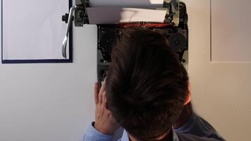 un' uomo è utilizzando un' macchina da scrivere per Stampa su un' documento video