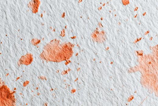 Texture of red paint splatters on white paper surface photo